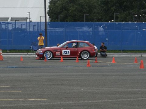 2001 Mercury Grand Marquis - A red BMW M coupe, identified by the number 737 on its door, is positioned on a track with orange cones surrounding it.