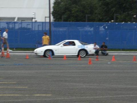 2001 Mercury Grand Marquis - A white sports car with blue numbers on its side navigates a course marked by orange cones.