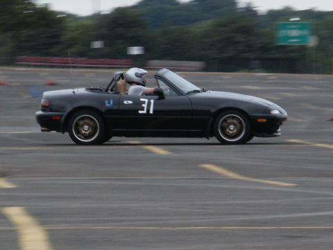 2001 Mercury Grand Marquis - A black convertible sports car with racing number 31 drives on a track.