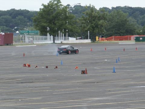 2001 Mercury Grand Marquis - Sports car performing a drift maneuver in a cone-marked parking lot.