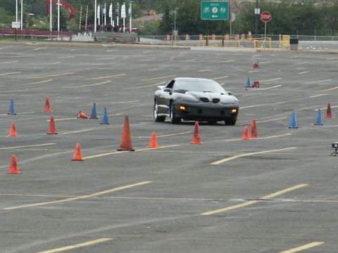 2001 Mercury Grand Marquis - Black Pontiac Firebird Trans Am navigates an autocross course with traffic cones.