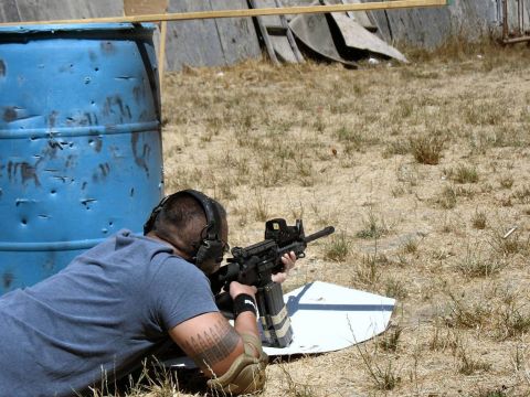 1990 Ford Bronco - A man lies prone on the ground aiming a rifle at a target during a shooting match.