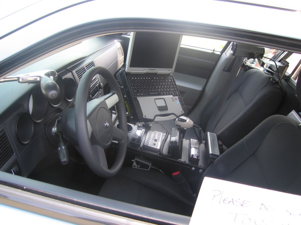 Police car interior with laptop, console and do-not-touch sign