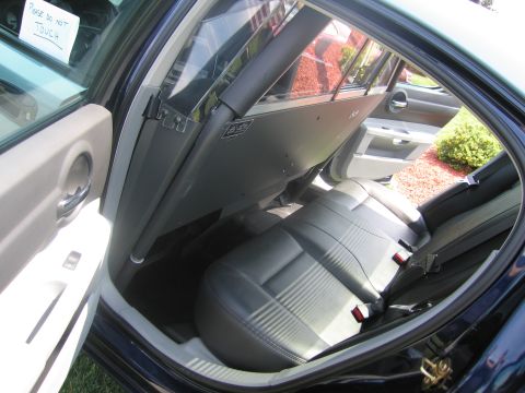 1991 Ford LTD Crown Victoria - View through the open rear door of a dark blue sedan showing gray-and-black leather rear seats and a paper sign reading please do not touch.