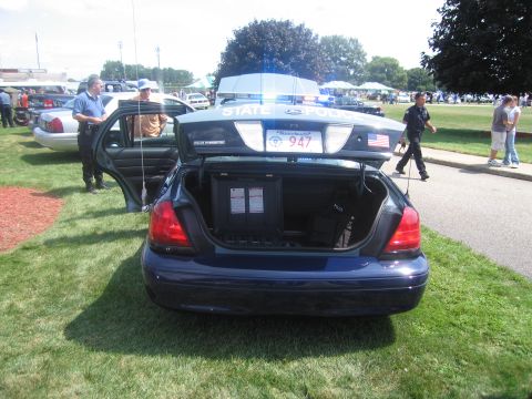 1991 Ford LTD Crown Victoria - Rear view of a dark blue Ford state police sedan with open trunk revealing mounted equipment and a plate reading 947.