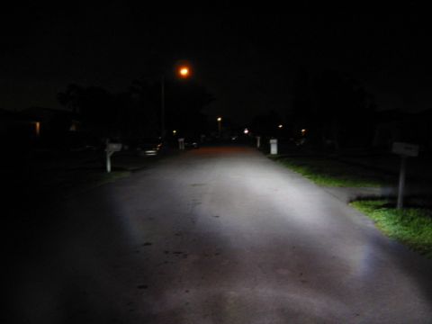 1995 Ford Thunderbird - Bright headlights cut through the darkness on a residential street, with the Supermotors.net logo in the corner.