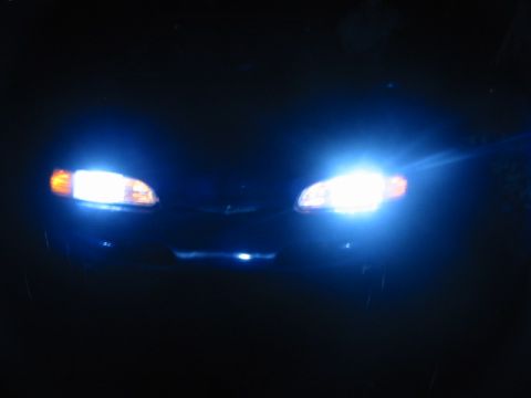 1995 Ford Thunderbird - 1995 Ford Thunderbird headlights illuminated at night.