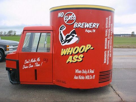 1987 Ford Thunderbird - A custom three-wheeled vehicle is branded with 'No Class Brewery' and 'Whoop-Ass' slogans, resembling a large can.