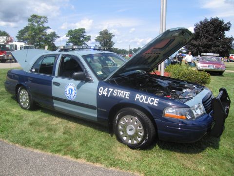 1991 Ford LTD Crown Victoria - Side view of a two-tone blue State Police Ford Crown Victoria with hood raised and an agency seal, lettered 947 State Police on the door.