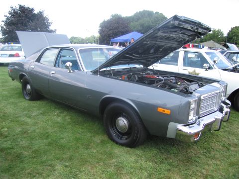 1991 Ford LTD Crown Victoria - gray 1970s full-size four-door sedan with its hood and trunk open, displayed on grass among other cars at a show.