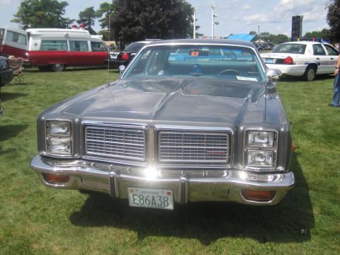 1991 Ford LTD Crown Victoria - Front view of a silver 1970s full-size sedan with quad stacked headlights, chrome grille and a Massachusetts antique plate E86A38.