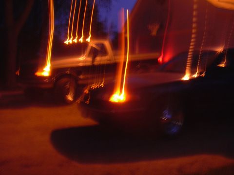 1996 Ford Crown Victoria - Light trails streak across the frame, obscuring the details of two vehicles parked at night.