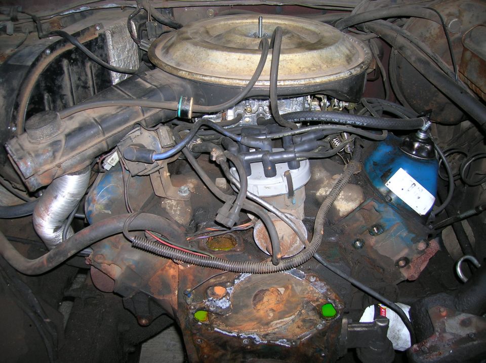 Engine bay with carburetor, distributor, and air cleaner visible. Some rust and wear present