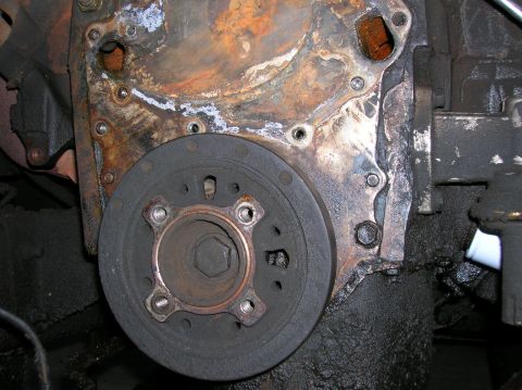 1978 Ford F-250 - Close-up of an engine's timing cover and crankshaft pulley, showing wear and oil residue.
