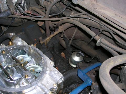 1978 Ford F-250 - A close-up view of a vehicle's engine compartment, focusing on the carburetor and surrounding components.