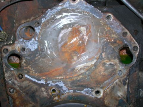 1978 Ford F-250 - Corroded water pump housing on an engine block with visible green coolant.