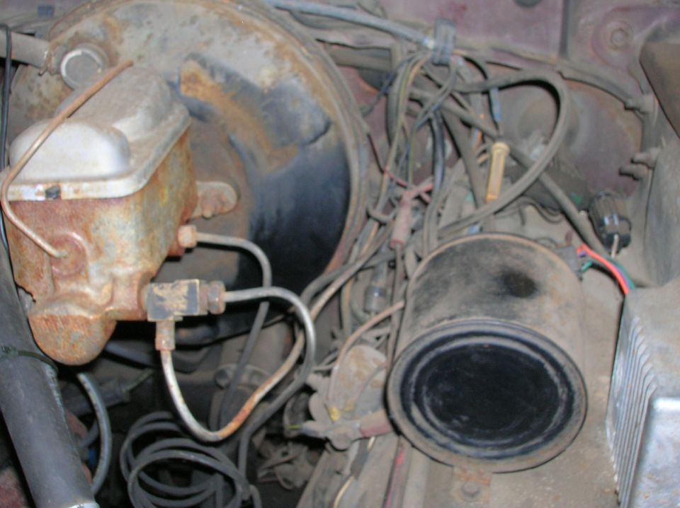 Rusted brake master cylinder and wiring harness in a vehicle engine bay