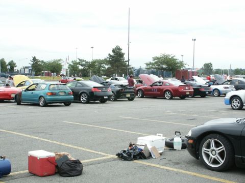 2001 Mercury Grand Marquis - Cars parked in a lot with coolers and gear scattered around.