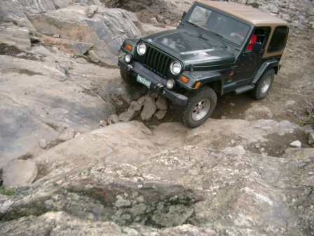 1995 Ford Bronco - Jeep Wrangler TJ off-roading on a challenging rocky path.