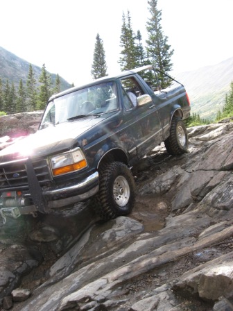 1995 Ford Bronco - This 1995 Ford Bronco is shown tackling a challenging off-road course on a sunny day.