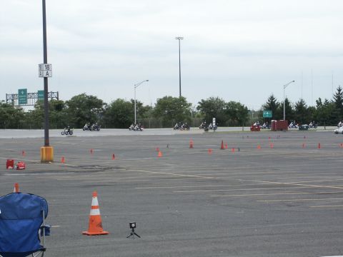 2001 Mercury Grand Marquis - Motorcycles navigate a cone course in a large paved area under an overcast sky.