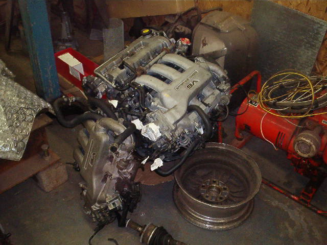 V6 engine and wheel in garage