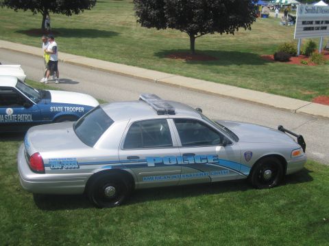 1991 Ford LTD Crown Victoria - silver Ford Crown Victoria marked POLICE for American International College is shown on grass near other cruisers.
