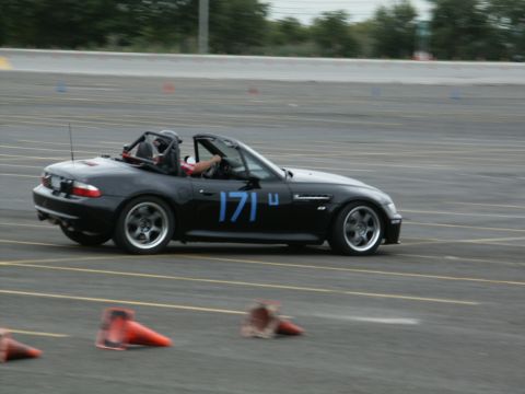 2001 Mercury Grand Marquis - A black convertible sports car with racing numbers navigates a course marked by orange cones.