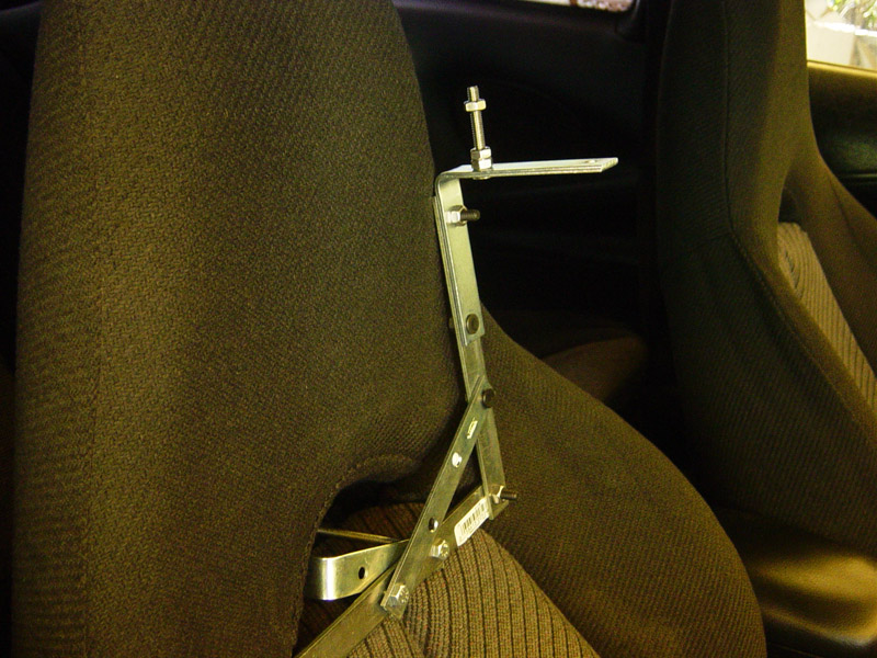 aftermarket metal bracket bolted to car seat headrest post