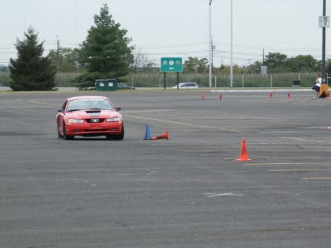 2001 Mercury Grand Marquis - A red 2001 Ford Mustang navigates a course marked by traffic cones.