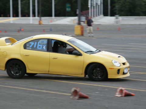 2001 Mercury Grand Marquis - A yellow Dodge Neon SRT-4 is seen in profile during a motorsports event, displaying racing numbers on its door.