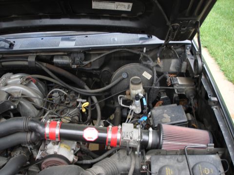 1994 Ford Bronco - Engine bay details, including an aftermarket air intake system with a red filter.