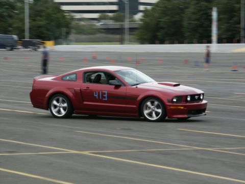 2001 Mercury Grand Marquis - Red Ford Mustang with racing numbers on the door navigates a course marked by cones.