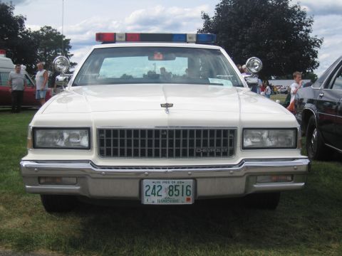 1991 Ford LTD Crown Victoria - Front view of a white Chevrolet Caprice police cruiser with a roof lightbar and a New Hampshire 'Live Free or Die' plate reading 242 8516,…
