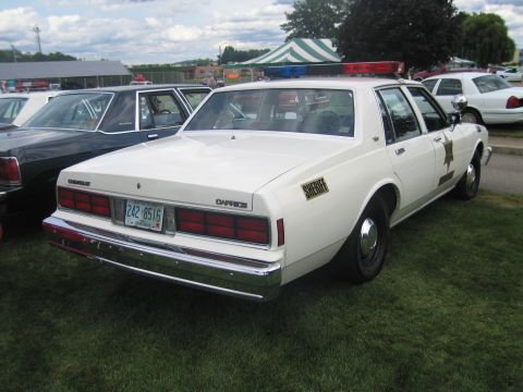 1991 Ford LTD Crown Victoria - Rear-three-quarter view of a white Chevrolet Caprice sheriff sedan with a gold star door decal, roof lightbar and plate 242 8516, parked at…