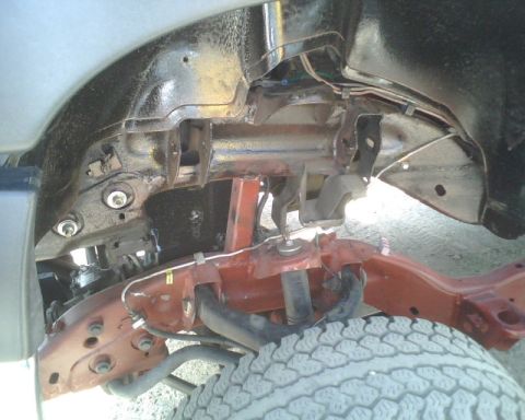 2000 Chevrolet Tahoe - A close-up view of a vehicle's undercarriage reveals its suspension and frame structure.