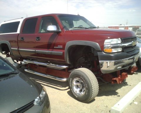 2000 Chevrolet Tahoe - This 2000 Chevrolet Tahoe pickup truck is modified with a lift kit and a white camper shell.