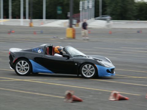 2001 Mercury Grand Marquis - A Lotus Elise navigates a course marked by cones, with a driver in racing gear at the wheel.