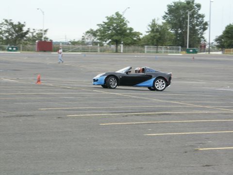 2001 Mercury Grand Marquis - A Lotus Elise convertible navigates a paved lot, possibly during a driving event.