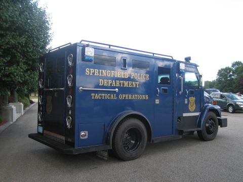 1991 Ford LTD Crown Victoria - Rear quarter view of a blue Springfield Police Department Tactical Operations armored truck with gold lettering and gun ports.