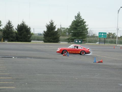 2001 Mercury Grand Marquis - A red sports car navigates a course marked by traffic cones on a cloudy day.
