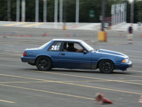2001 Mercury Grand Marquis - Blue Ford Mustang coupe with number 26 on the window, racing on a track.