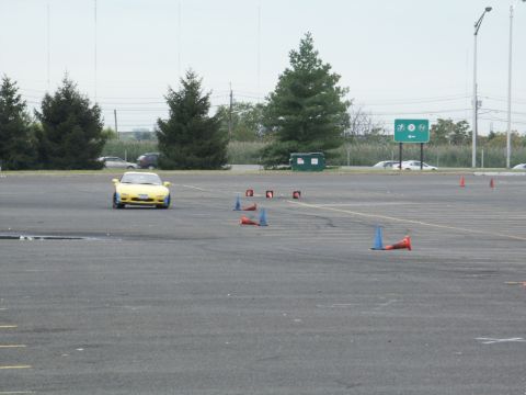 2001 Mercury Grand Marquis - A yellow sports car navigates a course marked by traffic cones in an open paved area.