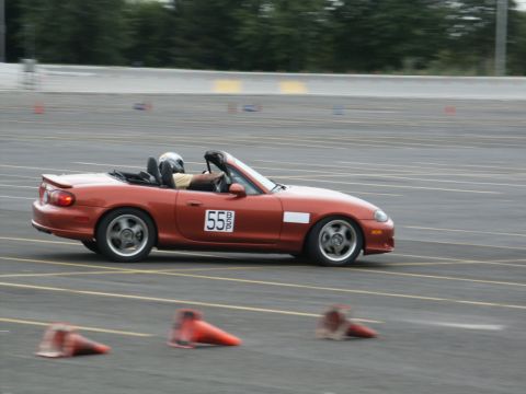2001 Mercury Grand Marquis - A red convertible sports car with racing number 55 navigates a track course.