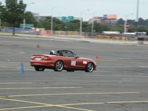 2001 Mercury Grand Marquis - A red convertible navigates a course marked by traffic cones on a cloudy day.