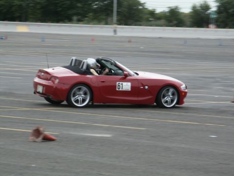 2001 Mercury Grand Marquis - A red convertible sports car with racing number 61 is seen on a track during an event.
