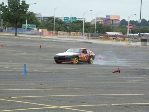 2001 Mercury Grand Marquis - A red and black Porsche 944 is seen drifting in a parking lot with cones set up for a course.