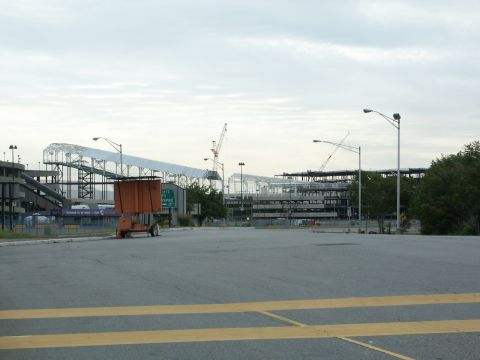 2001 Mercury Grand Marquis - Construction site with cranes and an orange utility cart in a parking lot under a cloudy sky.