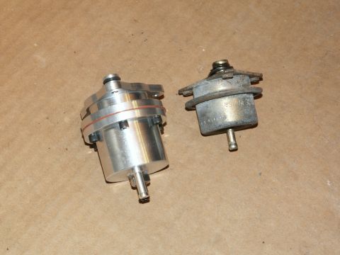1990 Ford Mustang - Two fuel pressure regulators are shown side-by-side on a textured surface.