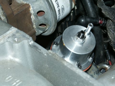 1990 Ford Mustang - A close-up view of a fuel pressure regulator, with a Ford filter visible in the background.